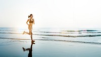 Sportive woman jogging at a beach