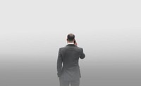 Rear view of a businessman talking on the phone in a smog