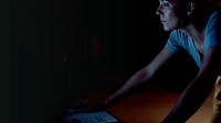 Woman using a computer in the dark