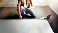 Guy kneeling on the floor with a big sheet of paper