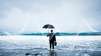 Businessman standing with an umbrella in the ocean