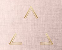 Gold triangle frame on a peach fabric background