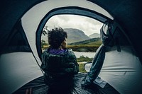 Woman sitting in tent, raining outside