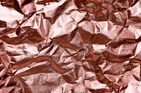 Crumpled rose gold paper textured background
