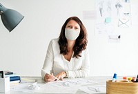 Designer in a mask in new normal office workplace 