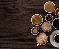 Coffee mugs on a dark brown wooden textured wallpaper