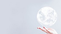 White globe over woman hand gray background