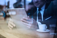 Businessman working on tablet in cafe