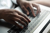 Woman typing on a laptop keyboard