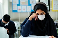 Muslim student wearing mask studying in a classroom