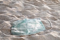 Ocean pollution photo with used face mask on the beach