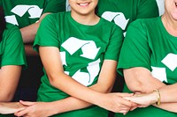 Environmentalists joining hands wearing recycling symbol t-shirts