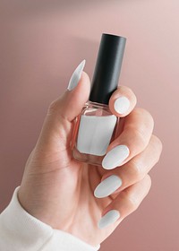 Woman’s hand holding nail polish bottle with design space