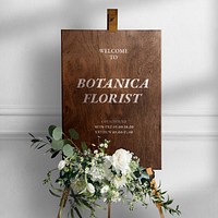 Wedding easel sign mockup psd in wooden texture with flowers