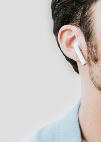 American man psd listening to music on wireless earphones closeup