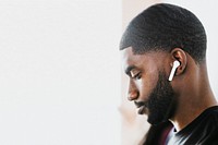 African American man listening to music on wireless earphones