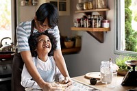 Young boy learning to bake with his mother