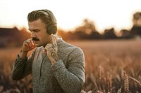 Handsome man wearing wireless headphones with nature view remixed media