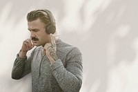 Handsome man wearing wireless headphones remixed media with shadow
