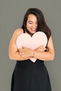 Portrait of a young woman hugging a heart shaped placard