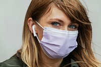 Woman in a face mask listening to music  during coronavirus pandemic