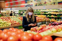 Woman in a face mask while shopping in a supermarket during coronavirus quarantine