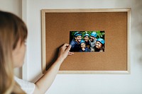Woman pinning a picture on a corkboard during coronavirus quarantine
