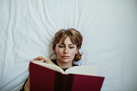 Woman reading a book on a bed during coronavirus quarantine