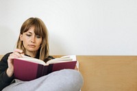 Woman reading a book on a bed during coronavirus quarantine