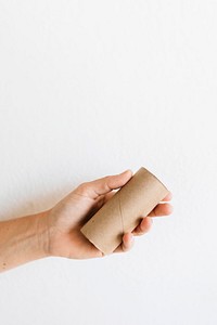 Hand with an empty tissue paper roll on a white background