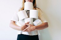 Woman with a pile of toilet tissue rolls
