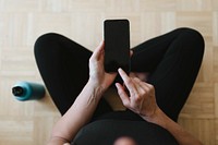 Woman in sportswear using her mobile phone during the coronavirus quarantine 