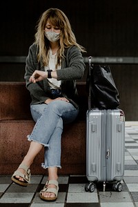 Woman looking at her watch while waiting for the train during the coronavirus pandemic