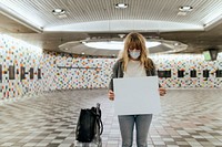 Woman with a suitcase holding a blank paper during the coronavirus outbreak