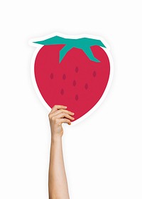 Hand holding a strawberry cardboard prop
