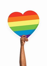 Hand holding a rainbow heart cardboard prop