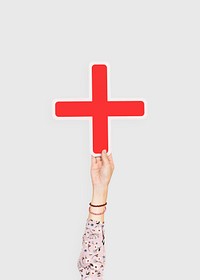 Arm raised and holding red cross icon