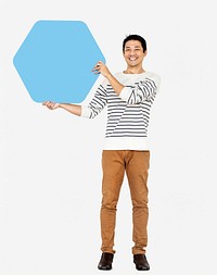 Cheerful man showing a blank blue hexagon board