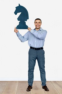 Businessman holding a chess piece