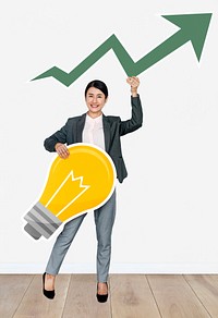 Businesswoman holding arrow and light bulb icons