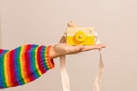 Woman with a yellow wooden camera toy