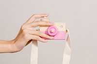 Woman with a pink wooden camera toy