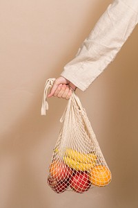 Woman using a net bag to carry fruits