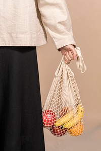 Woman using a net bag to carry fruits