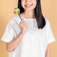 Happy woman in a white tee mockup holding a rainbow lollipop