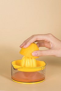 Woman making an orange juice from a manual juicer