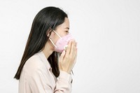 Asian woman wearing a mask and coughing