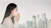 Asian woman wearing a mask and coughing in a polluted city