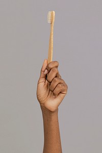 Hand showing a bamboo toothbrush mockup