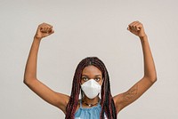 Black woman wearing a mask and raising her hands up in the air